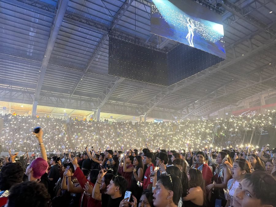 Kenia Os en la pantalla gigante del Auditorio mientras las gradas brillan con miles de luces de celular