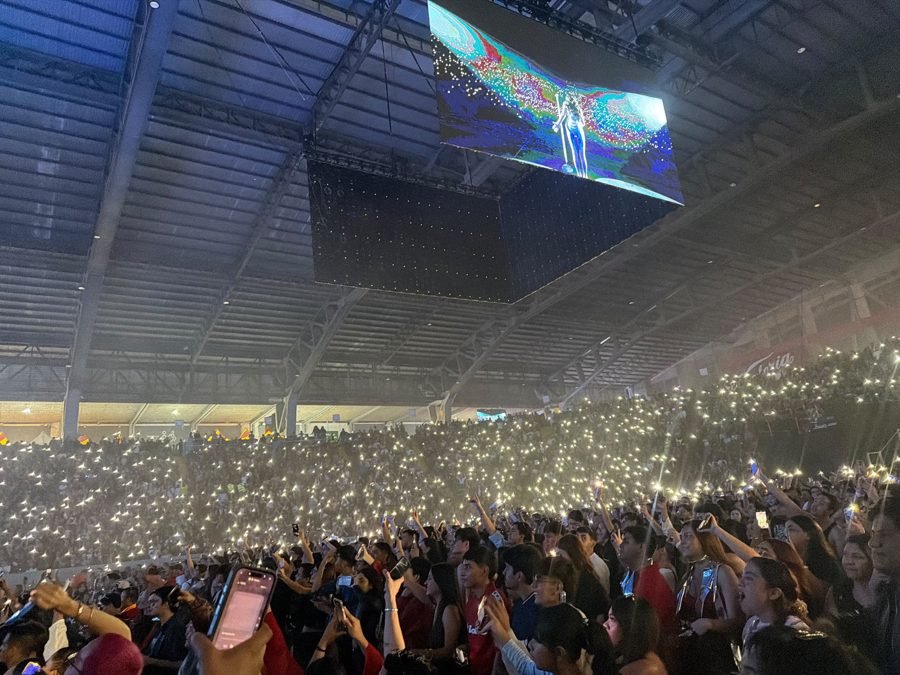 Las gradas del Auditorio Jalisco completamente encendidas con las luces de miles de celulares; en la pantalla gigante se ve a Kenia Os en el escenario