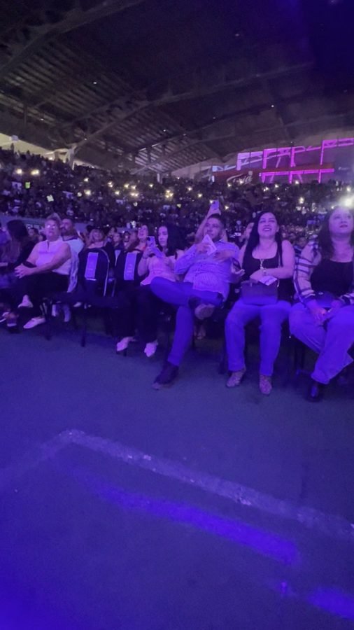 Público sentado en la pista numerada del Foro Principal con celulares en alto