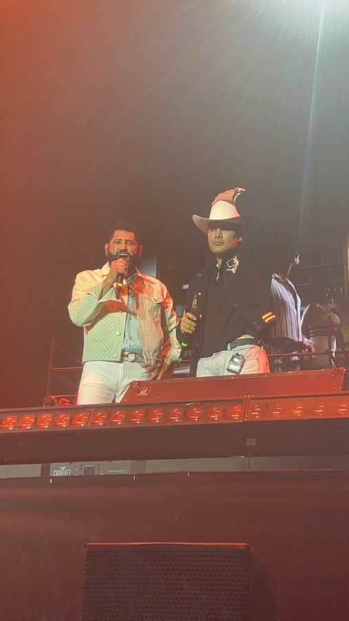 Pancho Barraza canta junto a un invitado de sombrero blanco y chamarra negra