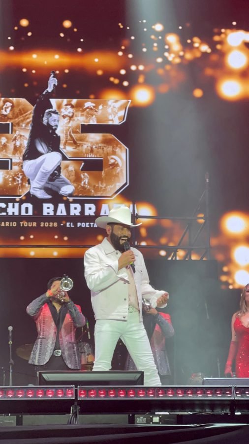 Pancho Barraza sonríe mientras canta con un trompetista detrás