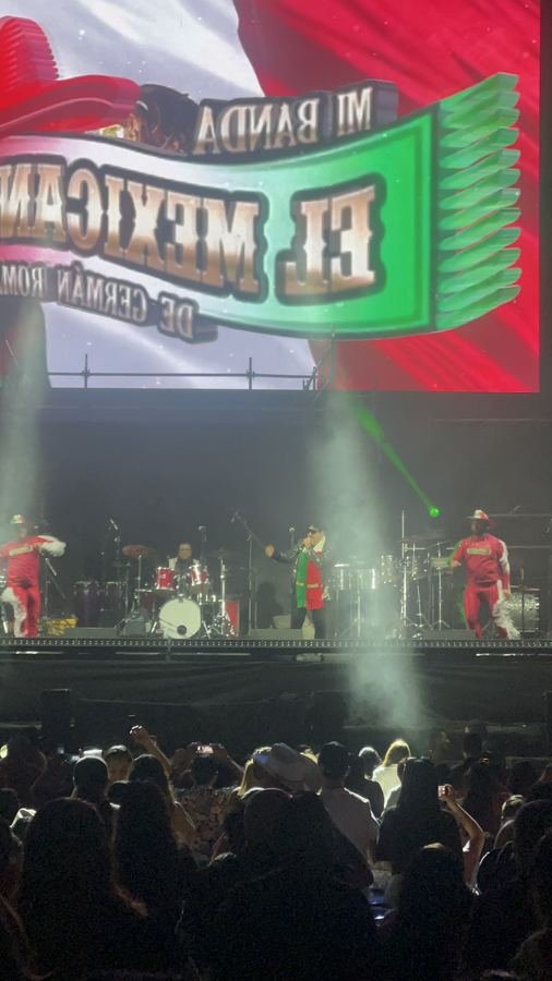 La pantalla de Mi Banda El Mexicano con un sombrero de charro rojo y los bailarines de rojo