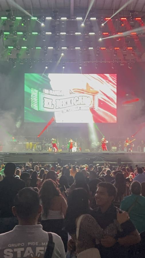El escenario con la pantalla tricolor y el público al frente