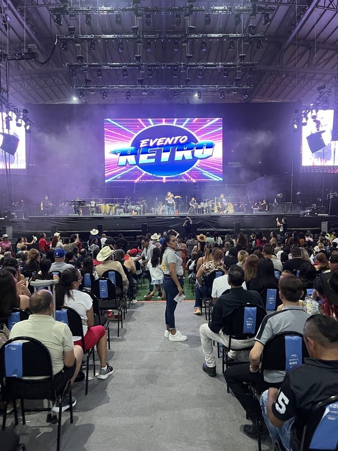 La pantalla gigante con el logo de neón del Evento Retro sobre el Foro