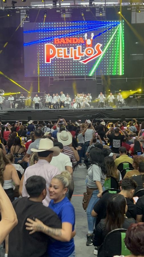 Una pareja baila abrazada en el pasillo frente al escenario de Banda Pelillos