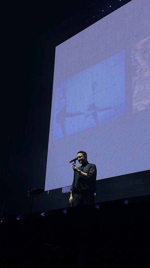 Jesús Navarro sonríe frente a una pantalla gigante en tonos blanco y azul