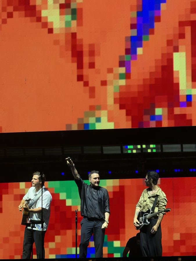 Reik frente a una pantalla de pixeles rojos