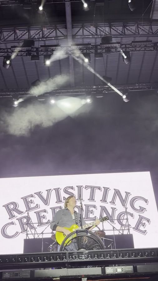 Reflectores blancos cruzan el humo sobre el guitarrista de la Les Paul dorada