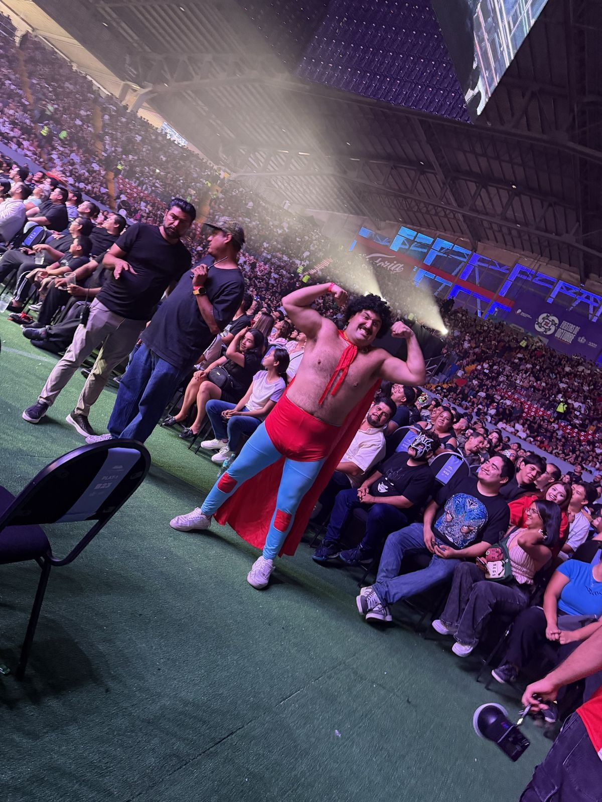 Aficionado disfrazado de luchador entre el público lleno
